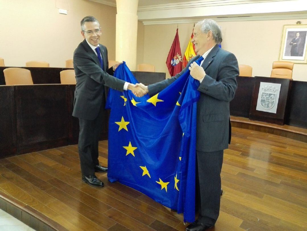 Ignacio Pando recibiendo una bandera de la Unión Europea