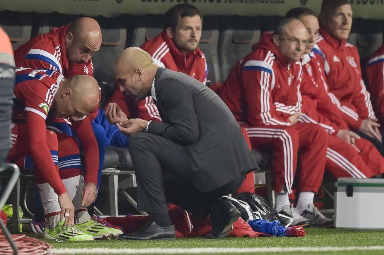 Bayern Munich's Dutch midfielder Arjen Robben (L) receives instructions from Spanish head coach Pep Guardiola before coming on during the German Cup DFB Pokal semi-final football match FC Bayern Munich v Borussia Dortmund in Munich, southern Germany, on April 28, 2015.  AFP PHOTO / GUENTER SCHIFFMANN 
 +++ RESTRICTIONS / EMBARGO x96 ACCORDING TO DFB RULES IMAGE SEQUENCES TO SIMULATE VIDEO IS NOT ALLOWED DURING MATCH TIME. MOBILE (MMS) USE IS NOT ALLOWED DURING AND FOR FURTHER TWO HOURS AFTER THE MATCH. FOR MORE INFORMATION CONTACT DFB DIRECTLY AT +49 69 67880