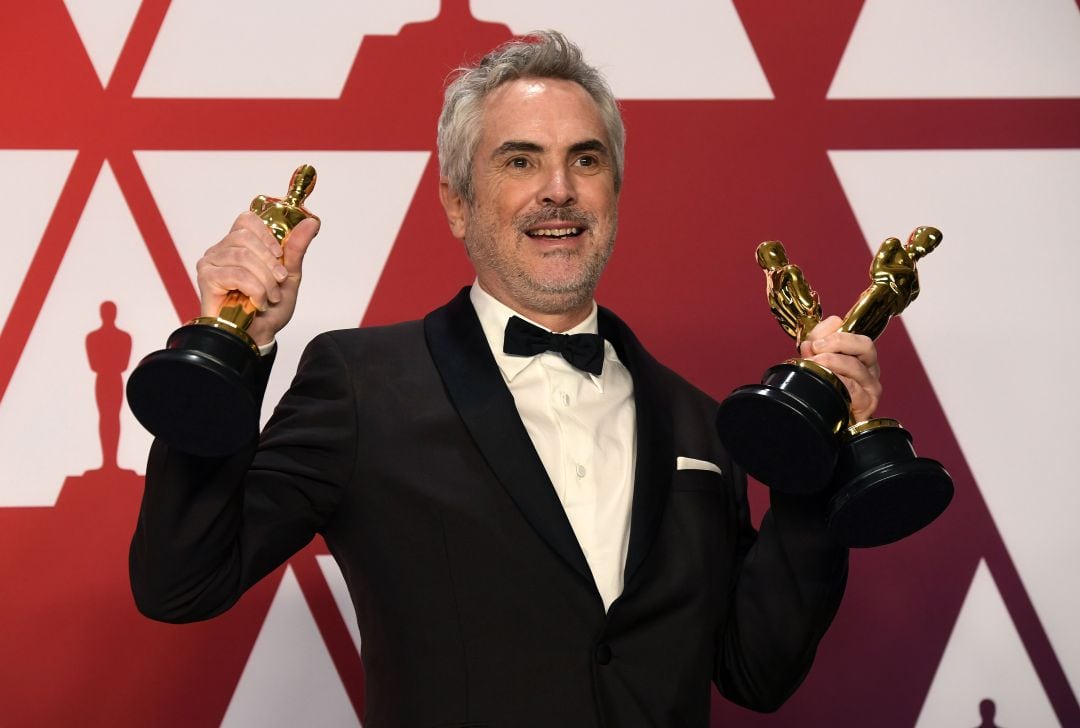 El directo mexicano Alfonso Cuarón con los tres premios en sus manos.