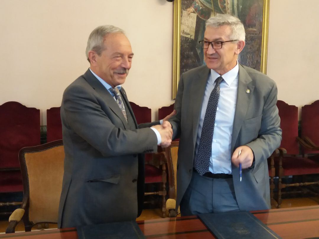 El Alcalde de Oviedo, Wenceslao López, y el Rector de la UNIOVI, Santiago García Granda estrechan sus manos tras la firma del convenio