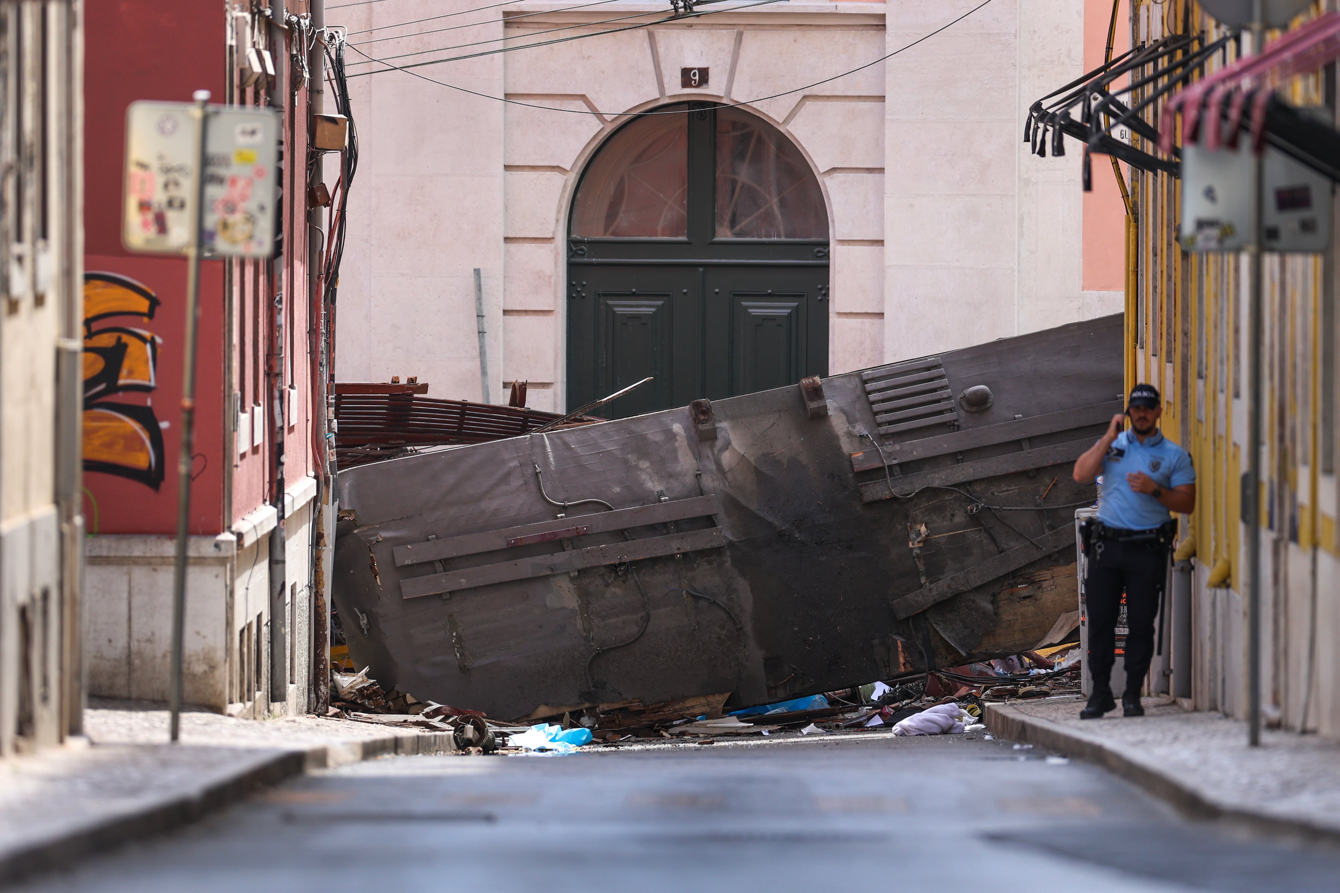 Un policía trabaja en el lugar en el que el pasado miércoles se produjo el accidente de funicular en Lisboa que dejó 16 muertos.
