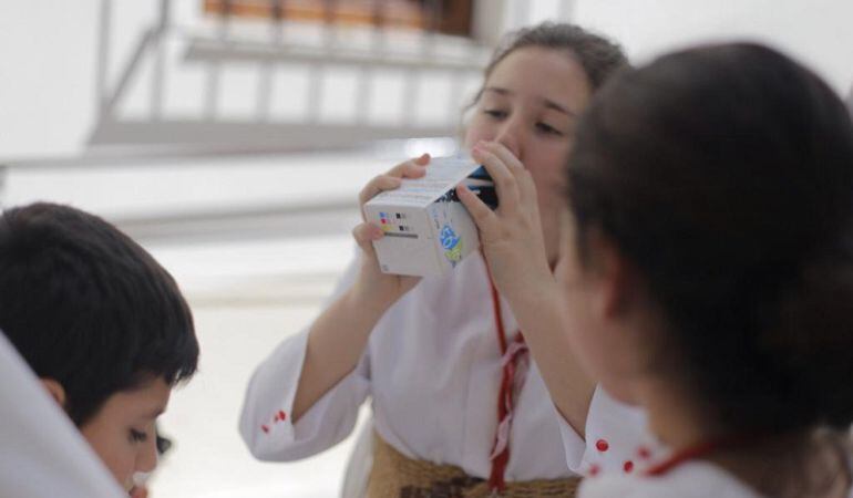 Una nazarena bebe agua, siguiendo el consejo de hidratarse bien realizado por las asistencias sanitarias