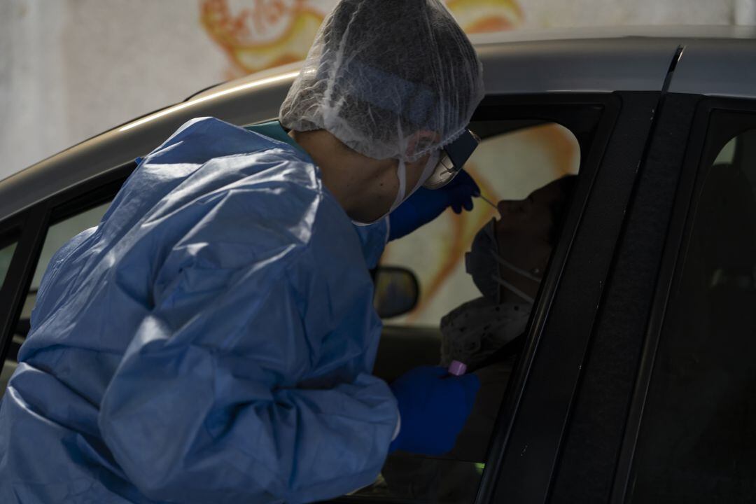 Una sanitaria haciendo una prueba PCR a un ciudadano desde su coche. 