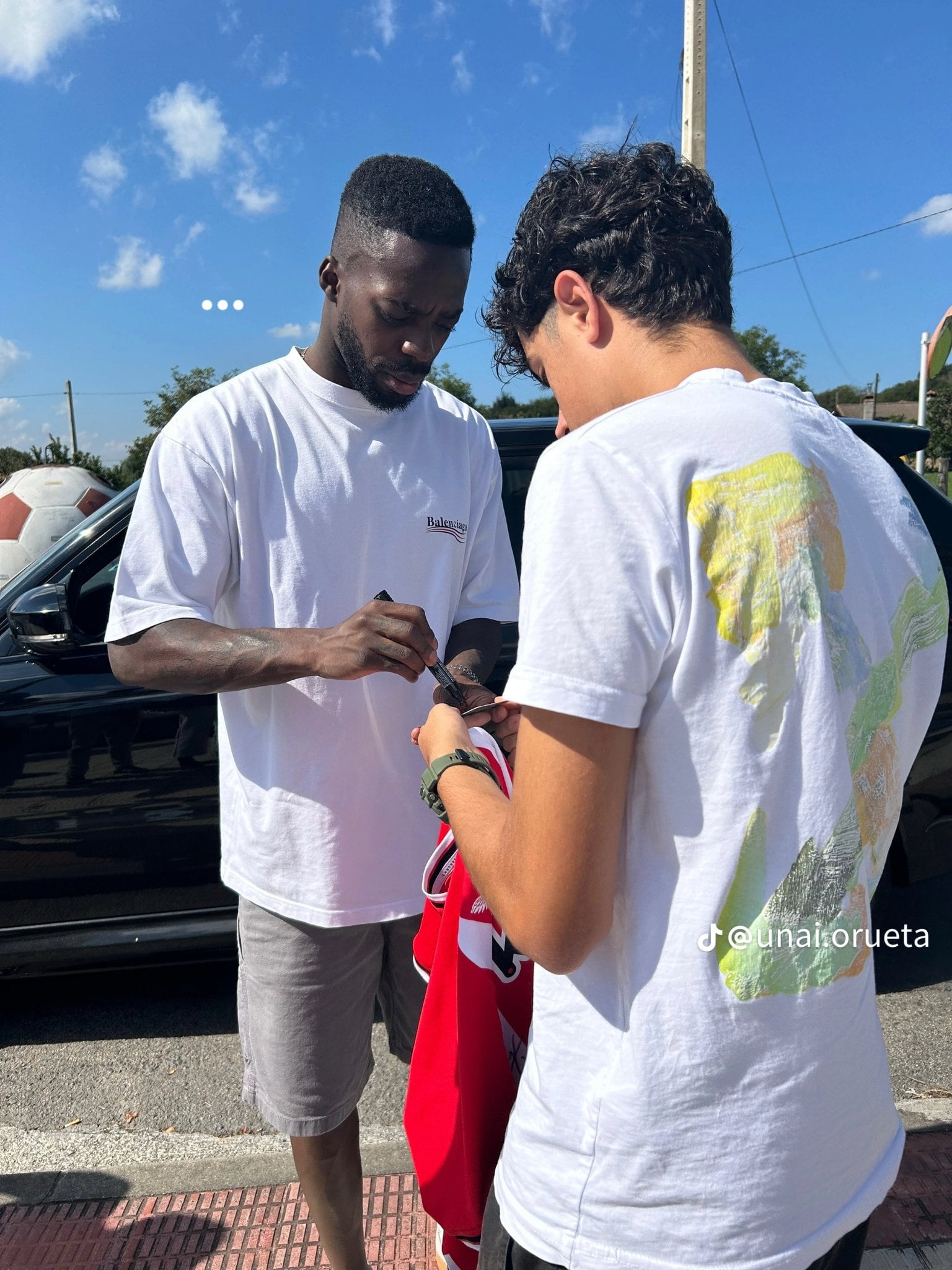 Iñaki Williams firmando la camiseta al aficionado del Athletic que después le bajó en coche