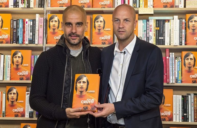 El entrenador español del Manchester City, Pep Guardiola, y el exfutbolista holandés Jordi Cruyff posan con un ejemplar durante la presentación de la biografía de Johan Cruyff.