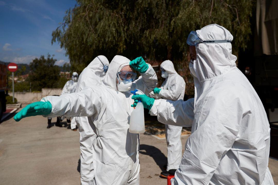 Efectivos del UME limpian el equipo tras desinfectar la residencia Benviure de Sant Boi del Llobregat, este lunes, vigesimotercer día de confinamiento por el estado de alerta declarado por el Gobierno por la pandemia de coronavirus