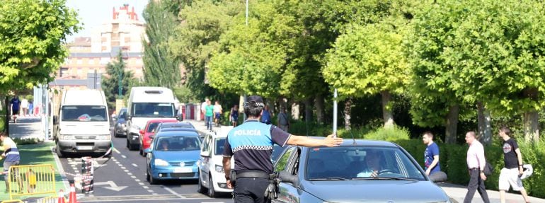 Agentes de la Policía Local informan a los conductores del corte de tráfico de vehículos a motor por el centro de Valladolid, debido a los altos índices de ozono en el aire