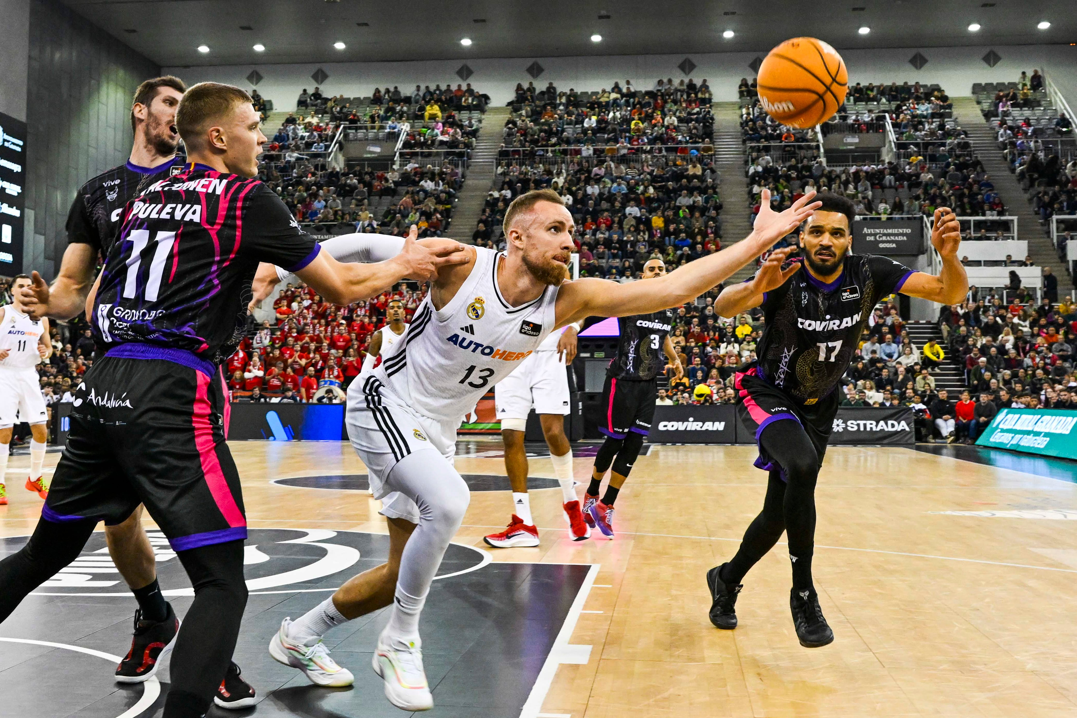 El alero bosnio del Real Madrid Dzanan Musa (c) rodeado por rivales del Covirán Granada, durante el partido de la jornada 14 de la Liga Endesa que Covirán Granada y Real Madrid disputan este miércoles en el Palacio de Deportes de Granada