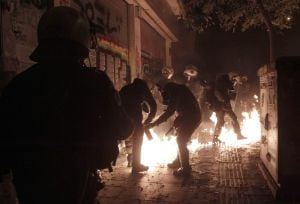 Los agentes antidisturbios tratan de apagar un cóctel molotov lanzado por uno de los manifetsantes.