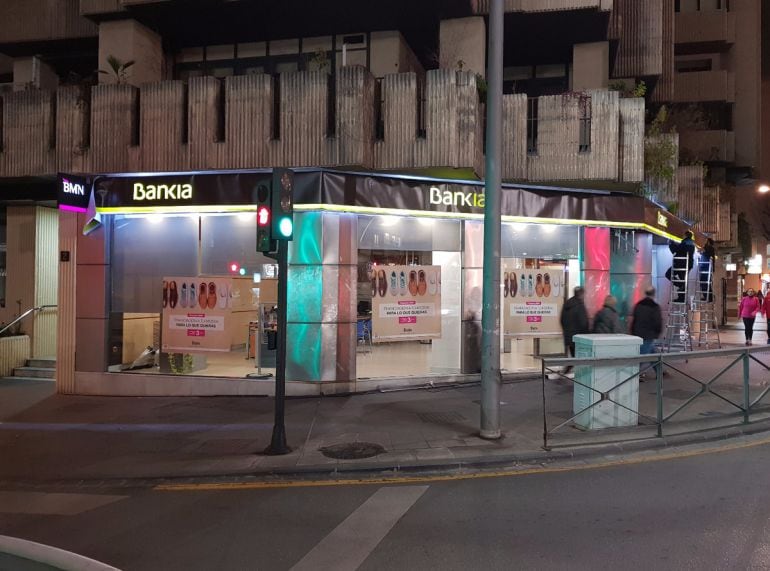 Operarios cambian la noche del jueves la rotulación a Bankia de una antigua oficina de BMN en Granada