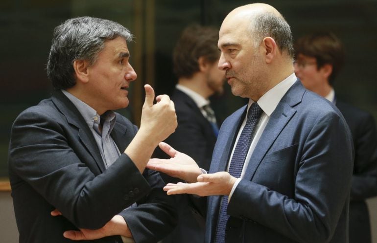 El comisario europeo de Asuntos Económicos y Monetarios, Pierre Moscovici conversa con el ministro griego de Finanzas, Euclides Tsakalotos.