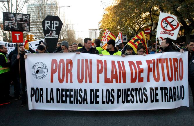 Manifestantes sostienen una pancarta en la que piden defender sus puestos de trabajo