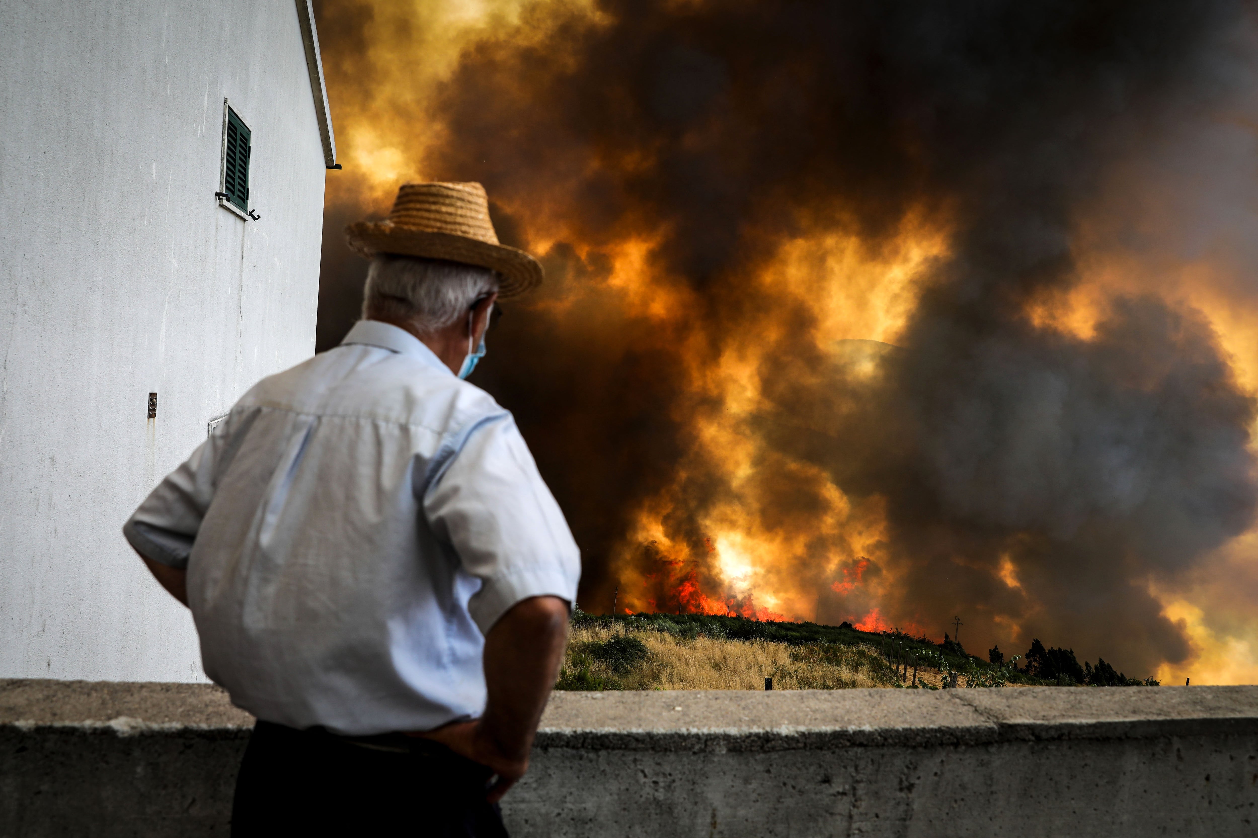Un hombre observa el fuego en uno de los incendios de Portugal, en la localidad de Gramaça