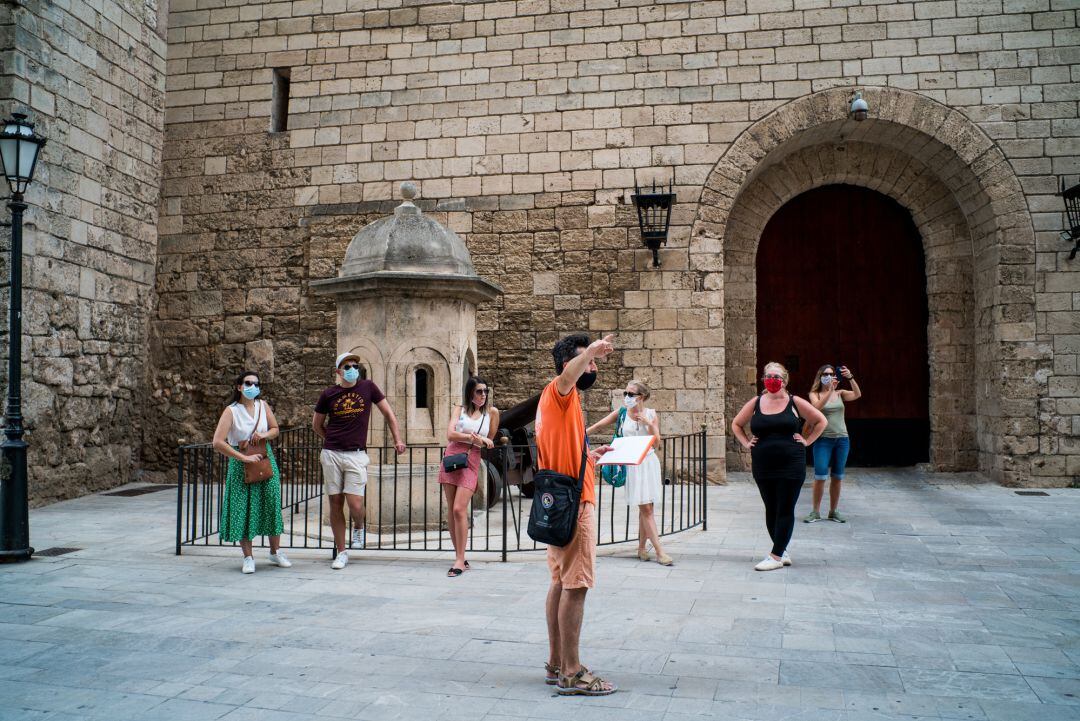 Varios turistas visitan el exterior de la Catedral de Santa María de Palma de Mallorca durante el primer día de uso obligatorio de la mascarilla en Baleares por el Covid-19, en Palma de Mallorca, Islas Baleares