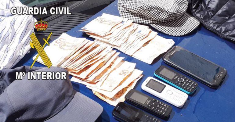 Dinero y objetos intervenidos por la Guardia Civil tras el robo en una entidad bancaria de La Carolina.