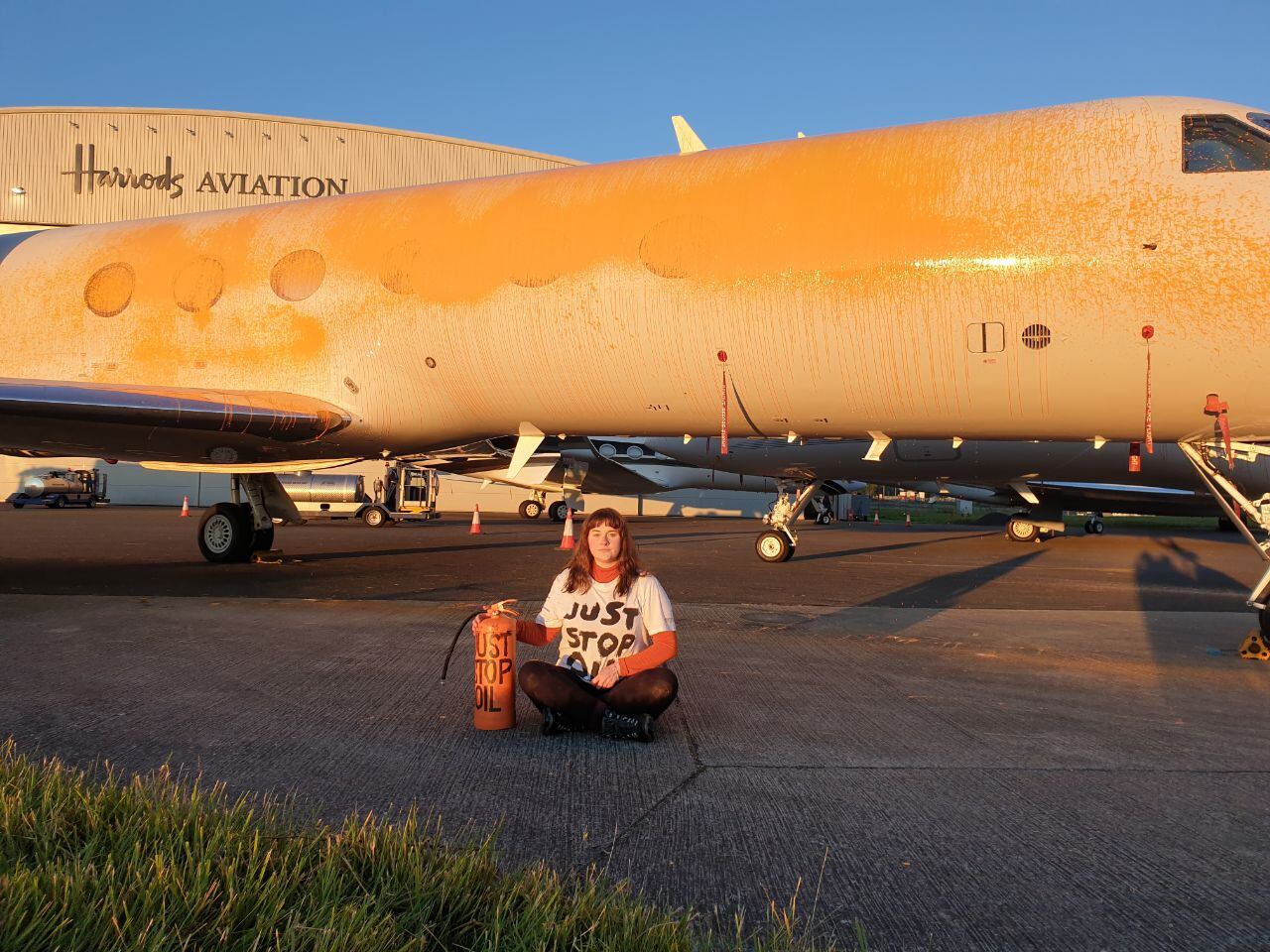 Una activista climática de Just Stop Oil frente a un avión en el aeropuerto de Stansted.