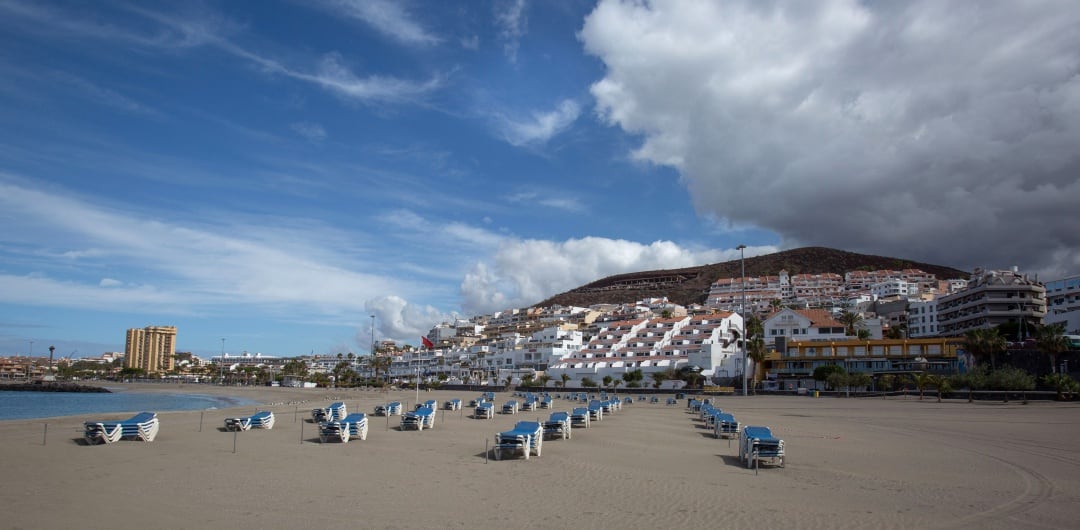 La playa de Las Vistas en la localidad de Los Cristianos (Arona, Tenerife) , es uno de los emplazamientos habituales de los miles de turistas que visitan Canarias. Ahora presenta una imagen muy poco habitual, prácticamente vacía