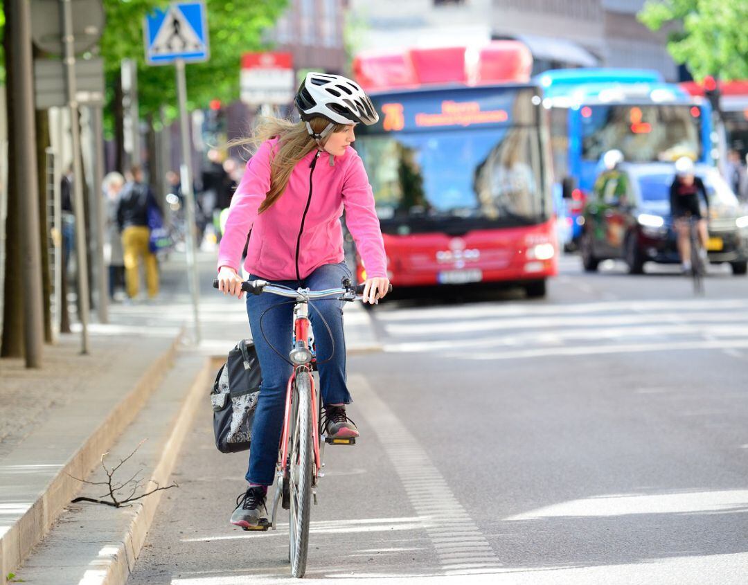 Ciclista circula delante de un autobús