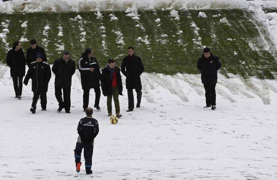 El arbitro Jose María sanchez Martinez realiza junto a los jueces de linea y el delegado de campo de Osasuna, las pruebas pertinentes con el esferico, antes de suspender el partido.