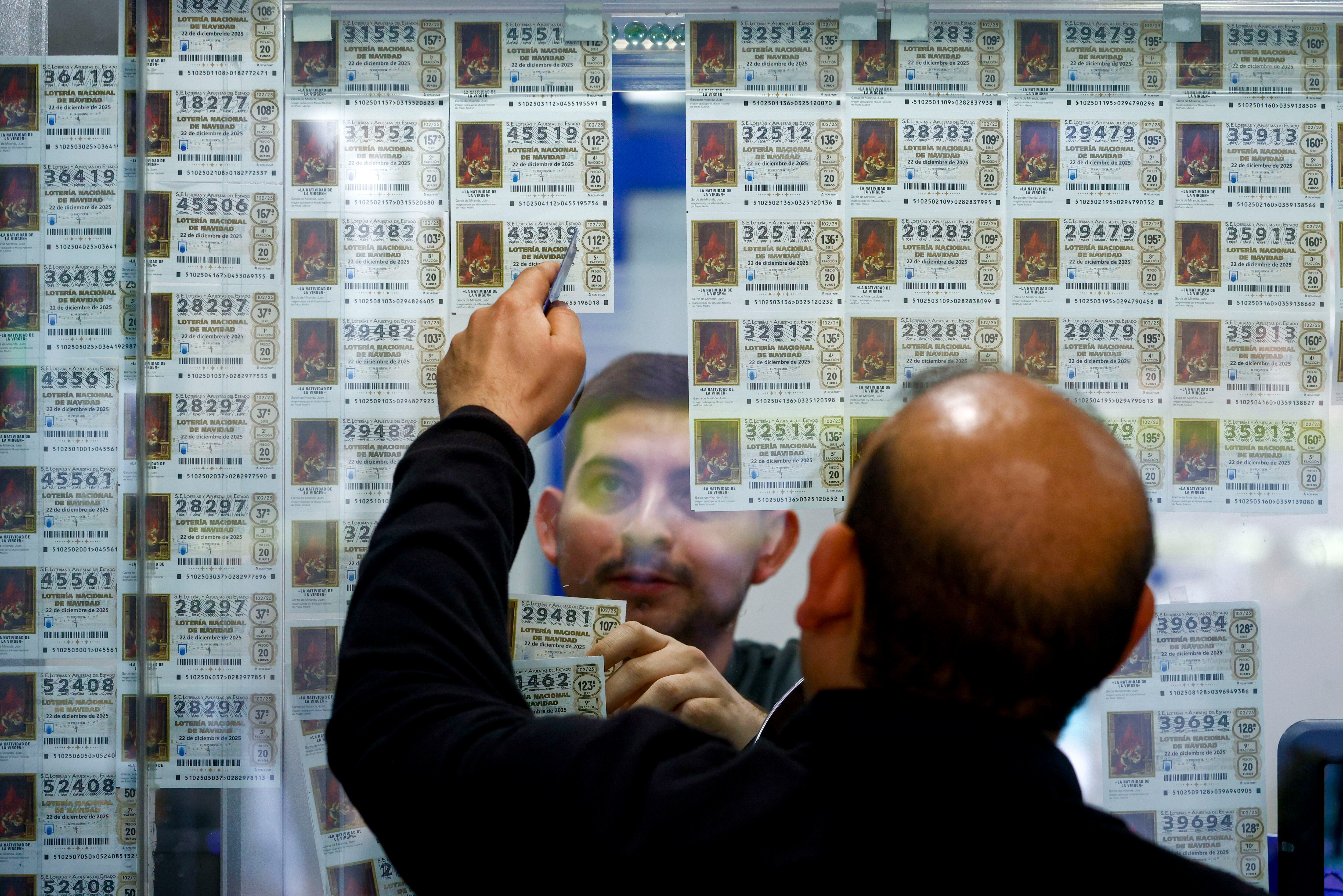 FOTODELDÍA GRAF8493. BARCELONA (ESPAÑA), 21/12/2025.- Un hombre observa billetes de lotería este domingo, en Barcelona (España). Los catalanes habrán invertido alrededor de 450 millones de euros en décimos en la tradicional Lotería de Navidad, una cifra que refleja la fuerte tradición y el arraigo de este sorteo en la comunidad. EFE/ Quique García