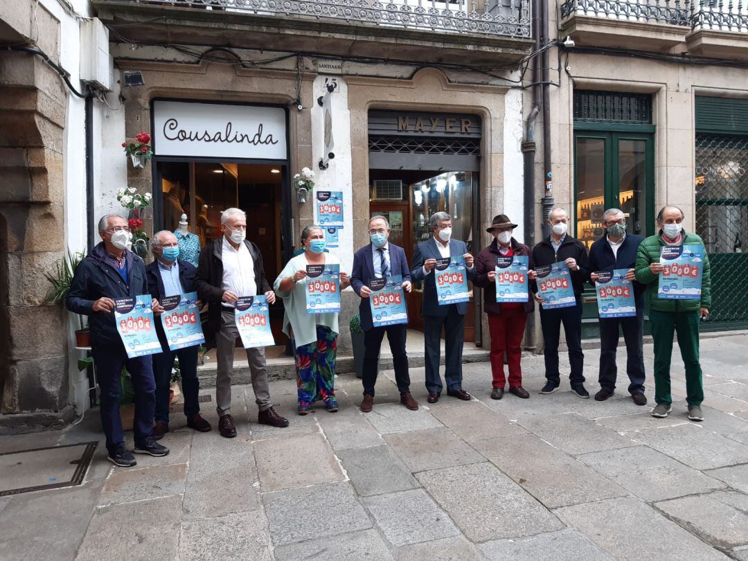 El alcalde de Santiago, Xosé Sanchez Bugallo, rodeado de comerciantes, con los carteles de la campaña 'Merca e Gaña'
