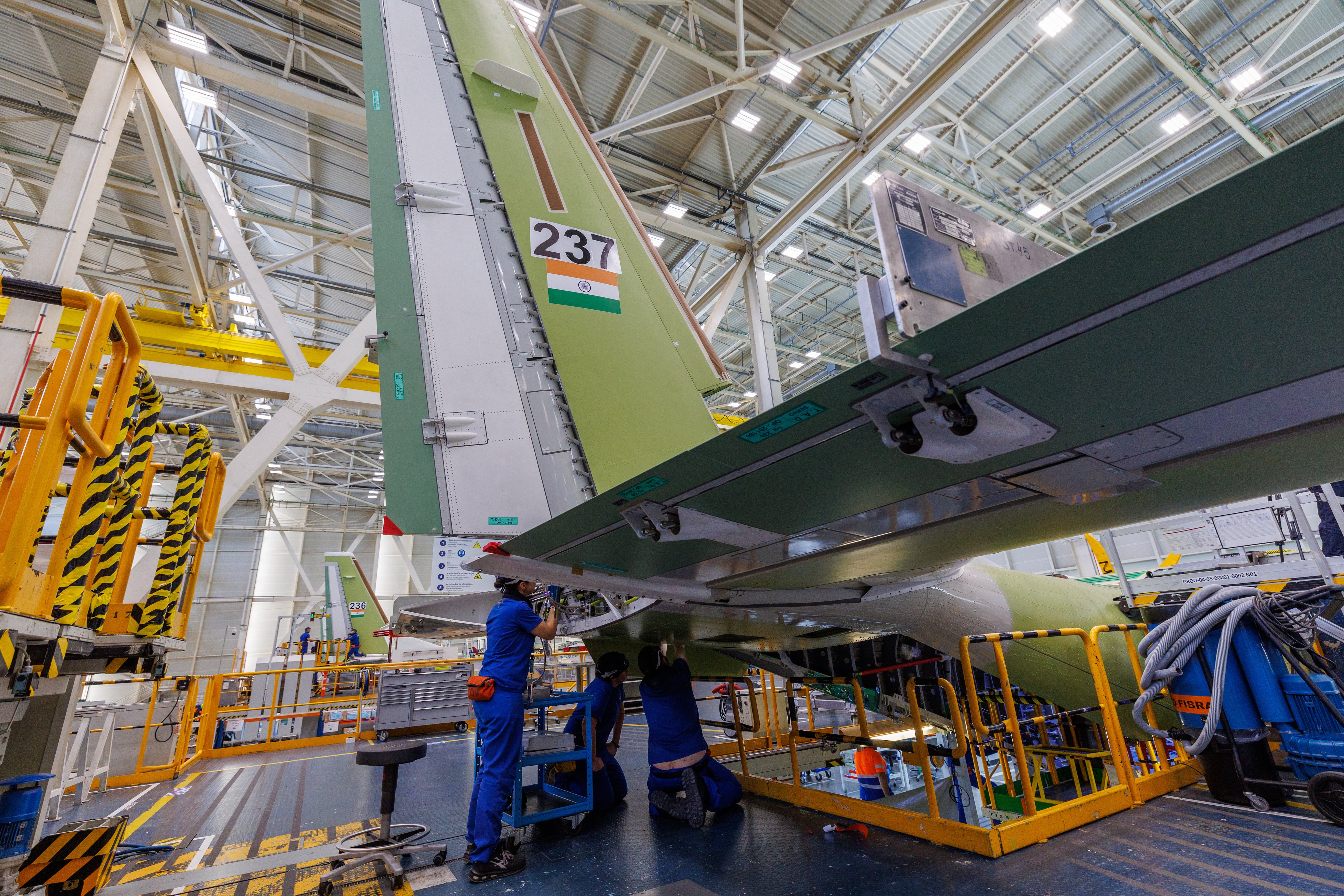 SEVILLA, 12/03/2024.- Varios operarios trabajan este martes en los estabilizadores de un avión C295 de transporte táctico medio en las instalaciones de Airbus en Sevilla, tras la reciente firma del pedido número 300 de estas aeronaves en los veinticinco años del programa. EFE/ Julio Muñoz