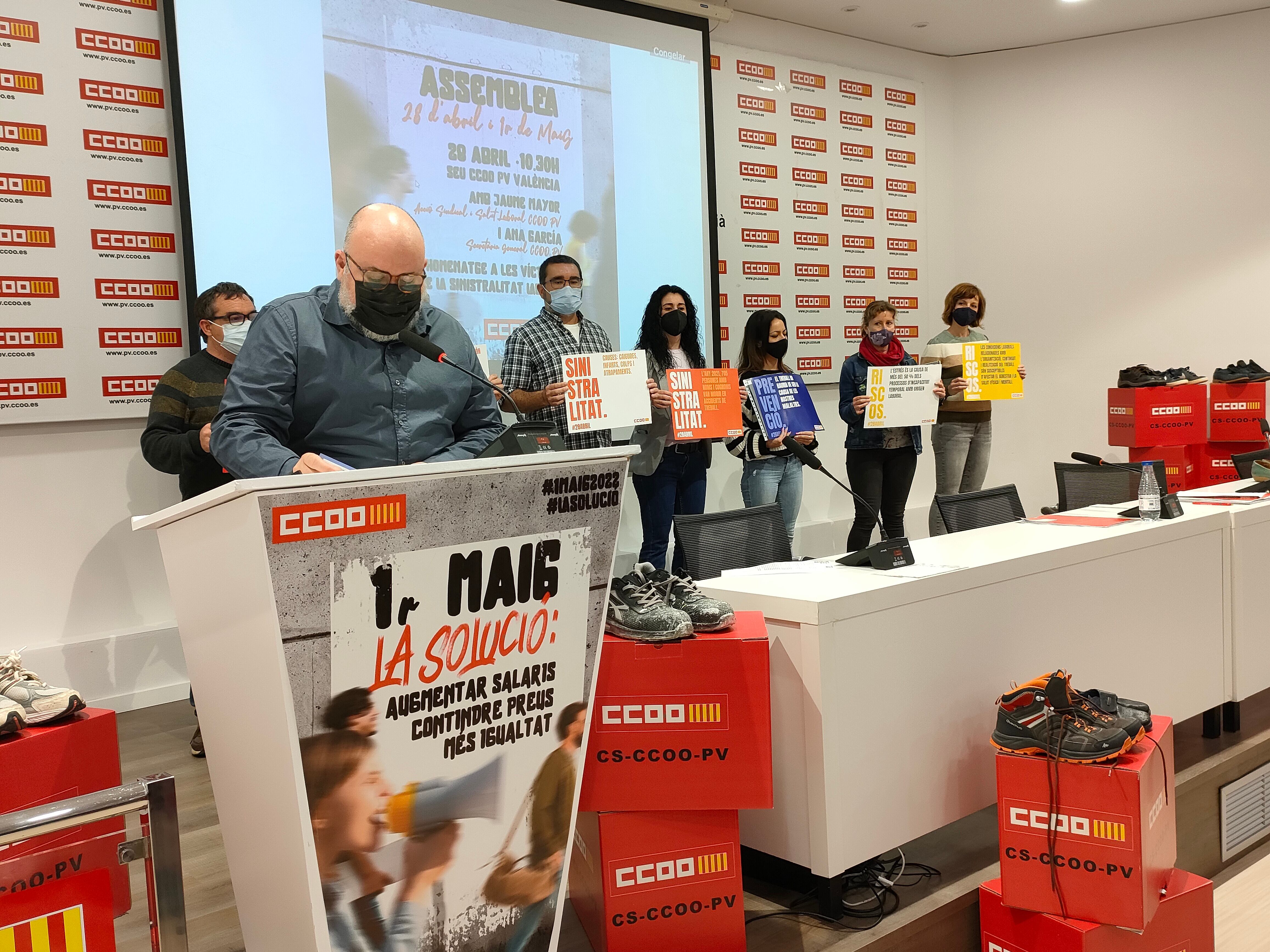Representantes de CCOO - PV junto a los zapatos en recuerdo a los 63 trabajadores y trabajadoras fallecidos en 2021 en accidentes laborales