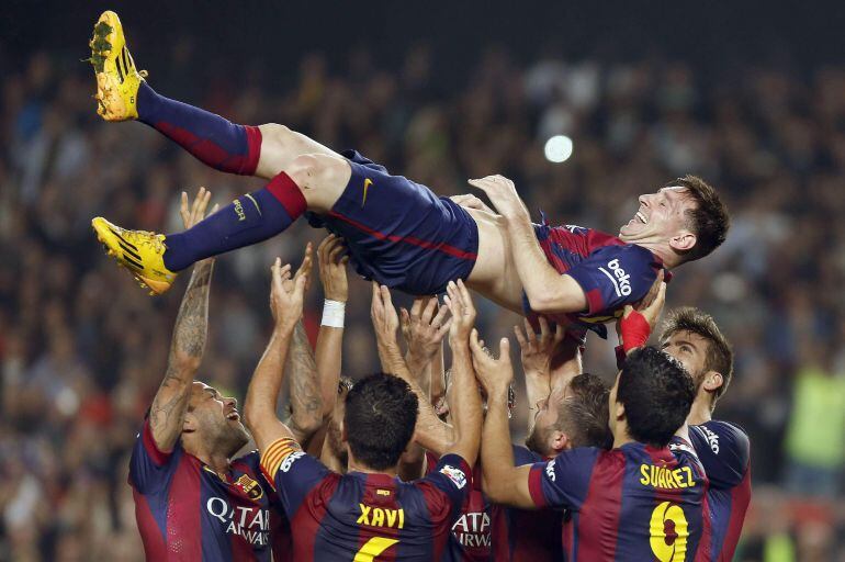 GRA316. BARCELONA, 22/11/2014.- El delantero argentino del FC Barcelona Lionel Andrés Messi (arriba) es manteado por sus compañeros tras conseguir su segundo gol, con el que se convierte en el máximo goleador de la historia de la Liga superando a Telmo Za