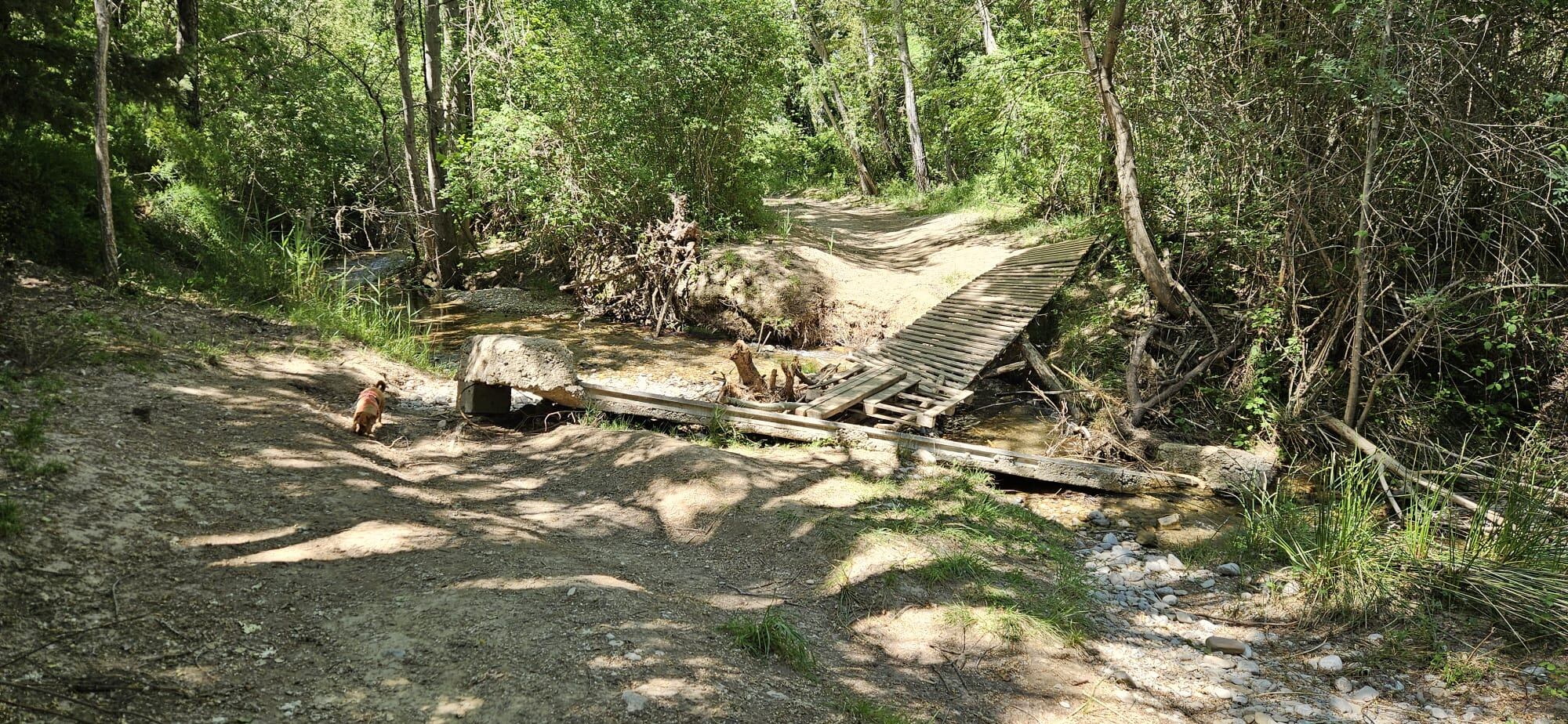 Una de las pasarelas, caída sobre el cauce del río