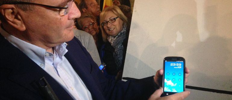 Carles Pellicer (CiU) ensenyant l'hora en la que es posa en marxa la campanya electoral.