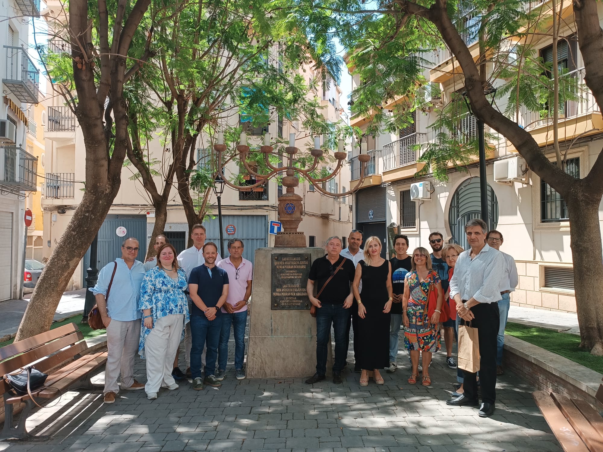 Concejales y participantes del paseo organizado por Iuventa junto a la Menorá ubicada en la conocida como Plaza de los Huérfanos.