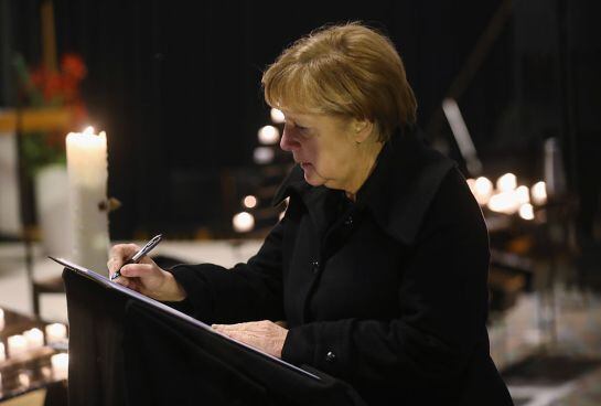 La canciller Angela Merkel firna en el libro de condolencias en la iglesia Kaiser Wilhelm.