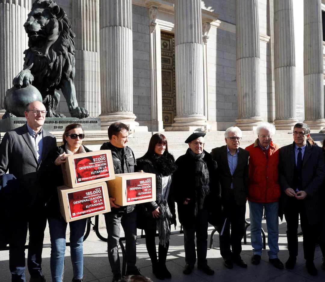 El presidente de la Comisión de Sanidad, Patxi López (d), y el portavoz socialista de Sanidad, Jesús María Fernández (3d), entre otros, posan a las puertas del Congreso de los Diputados junto a las dos familias que hoy han entregado más de 266.000 firmas para pedir la despenalización de la eutanasia y el suicidio médicamente asistido