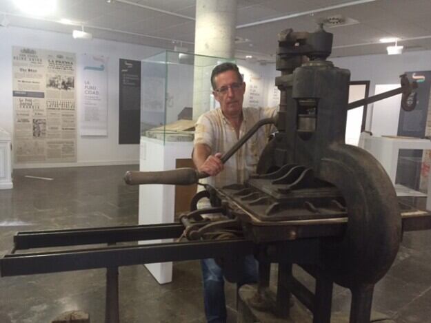 El periodista Rafael Bardají, con una de sus máquinas de imprenta, en la sala de exposiciones de la Diputación de Huesca