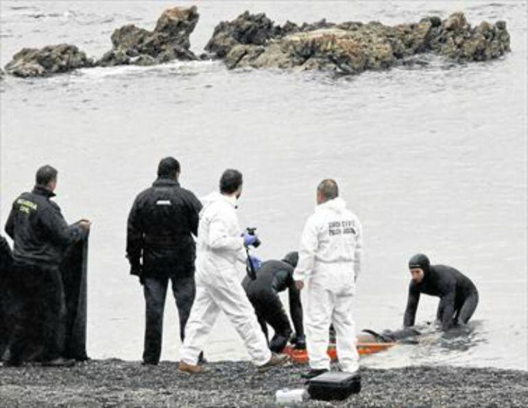 Agentes de la Guardia Civil sacan del agua el cadáver de uno de los inmigrantes fallecidos en Ceuta.