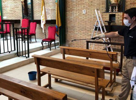 Desinfección de un banco en la parroquia.