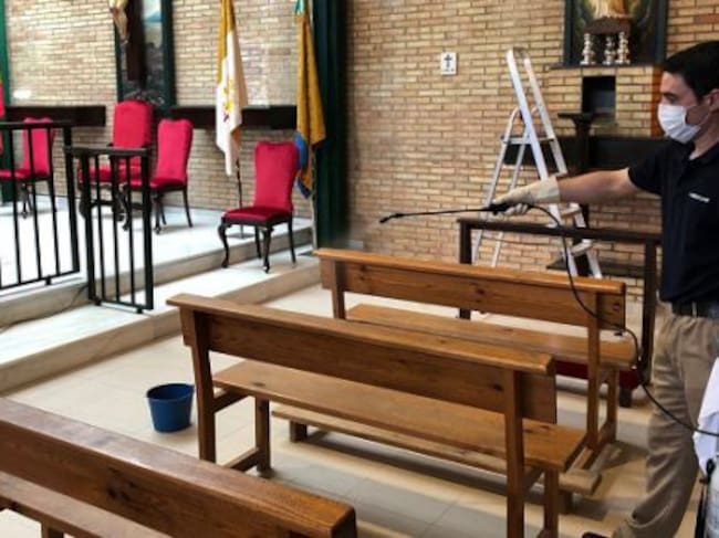 Desinfección de un banco en la parroquia.