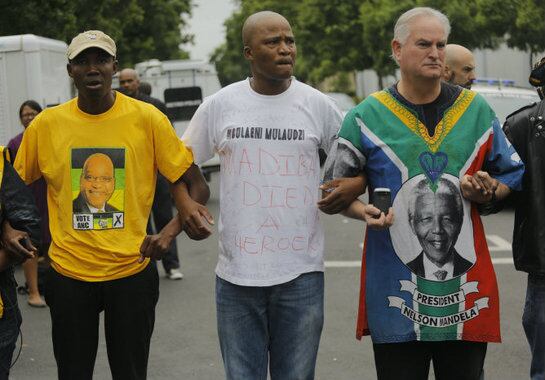 Varias personas lloran la muerte del expresidente sudafricano Nelson Mandela frente a su última residencia en Johannesburgo (Sudáfrica)