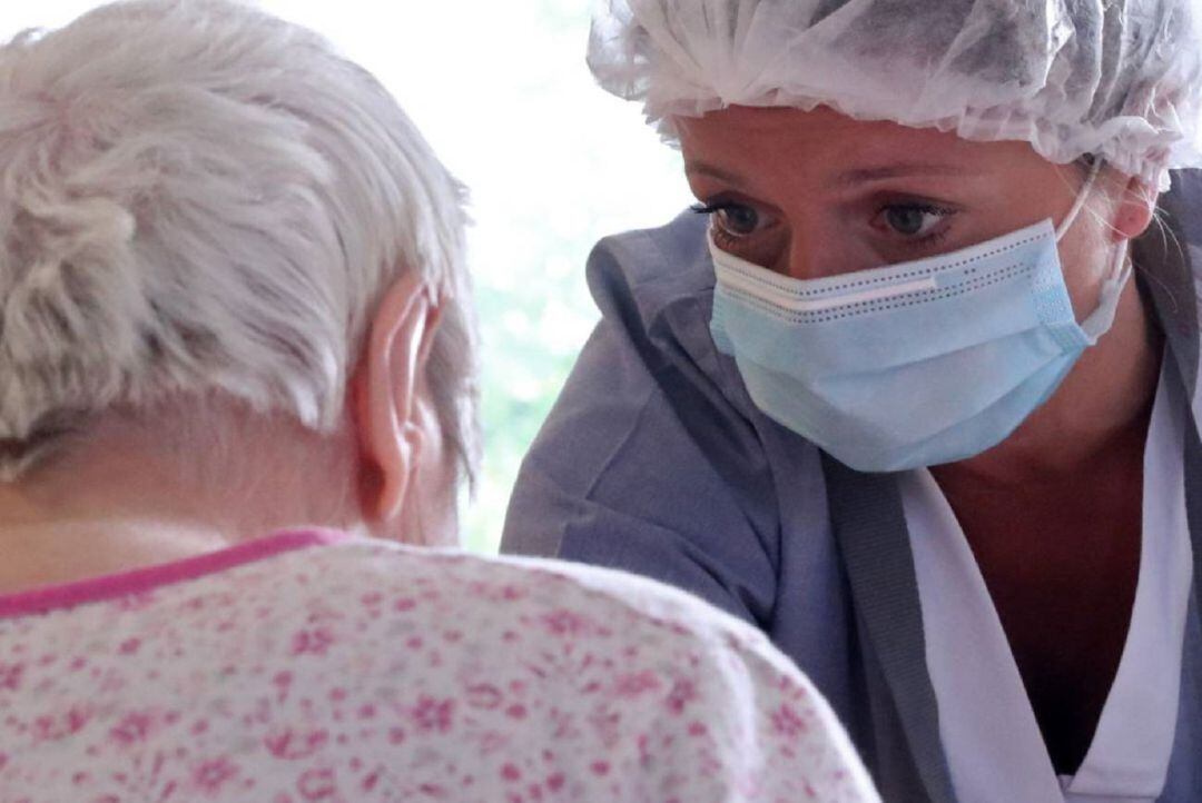 Una enfermera atiende a una paciente.