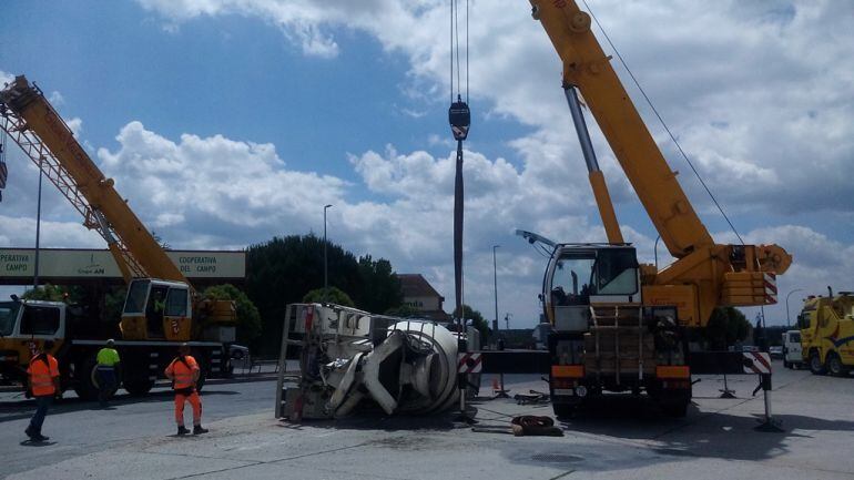 Dos gruas se disponen a levantar el camión accidentado en la rotonda sur de Cuéllar