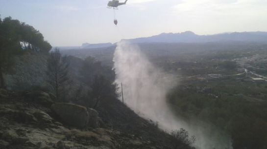 Medio aéreo trabajando en la extinción de las llamas del incendio declarado en la zona de Cumbres del Sol de Benitatxell