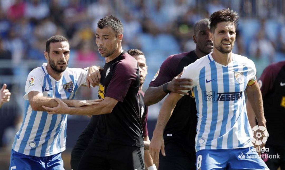 Javi Fuego (segundo por la izquierda) defiende al asturiano David Lombán durante el partido contra el Málaga