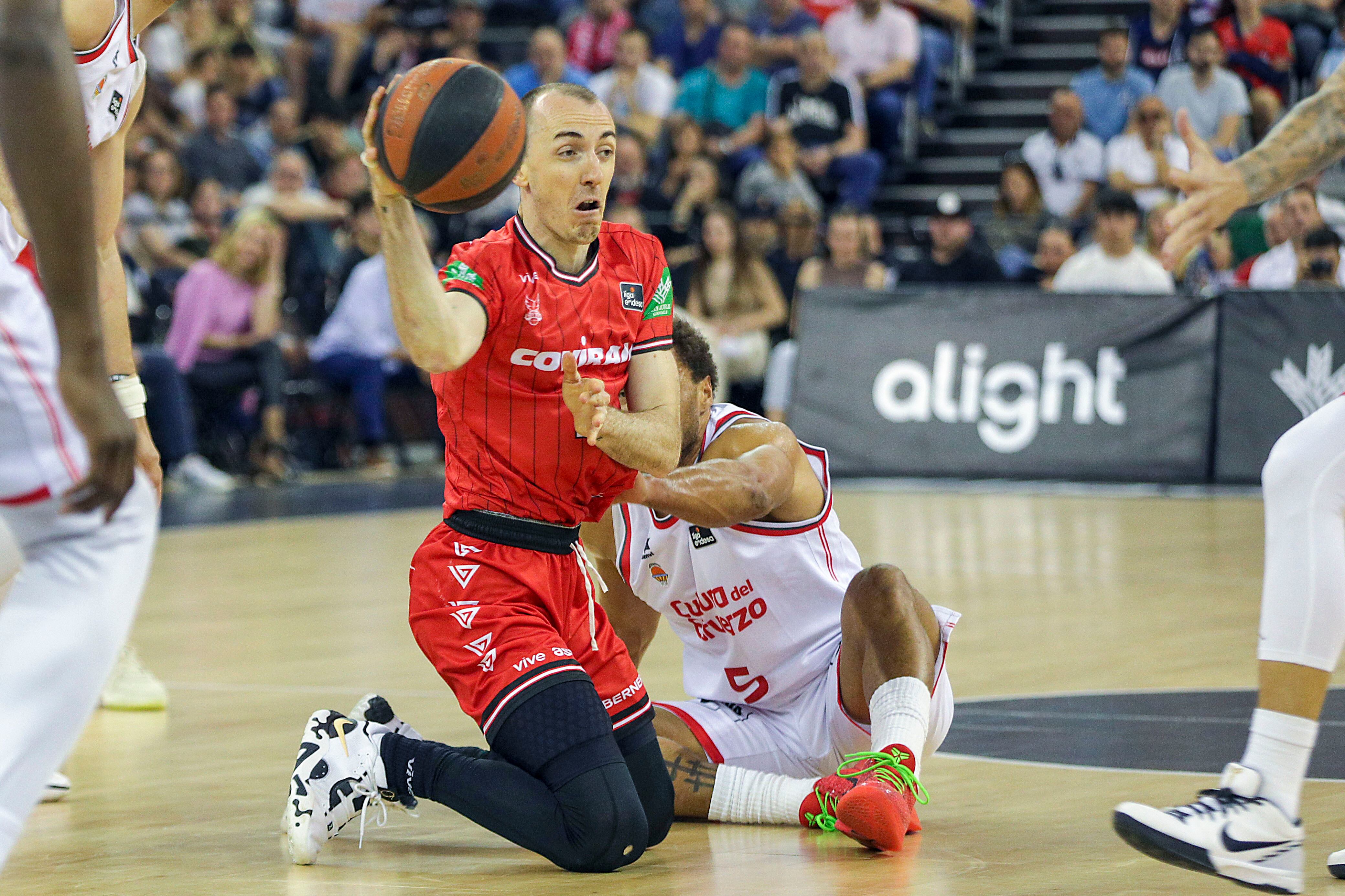 GRANADA, 14/04/2024.- El base de Covirán Granada, Jonathan Rousselle (i), con el balón ante el alero estadounidense de Valencia Basket, Justin Anderson, durante el encuentro correspondiente a la fase regular de la Liga Endesa disputado hoy domingo en el Palacio de Deportes de Granada. EFE / Pepe Torres.