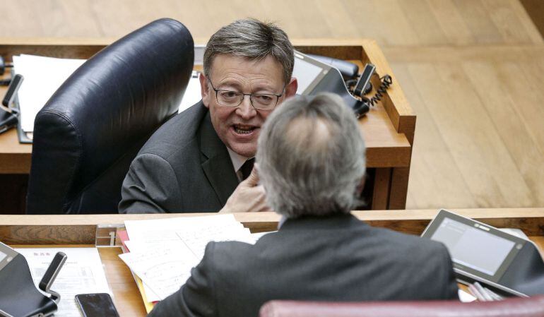 El president de la Generalitat, Ximo Puig, conversa con el portavoz del grupo socialista, Manuel Mata, durante el debate de las enmiendas a la totalidad presentada por el PP y Ciudadanos, al proyecto de ley de acompañamiento