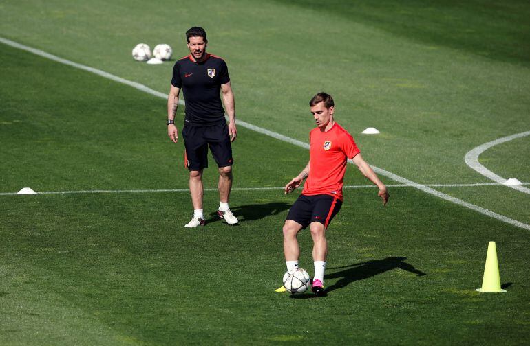 Atletico Madrid training - Majadahonda, Spain - 26/04/16 Atletico Madrid&#039;s Antoine Griezmann (R) kicks the ball near coach Diego &quot;Cholo&quot; Simeone during training prior to UEFA Champions League semi-final match against Bayern Munich. REUTERS/Sergio Perez