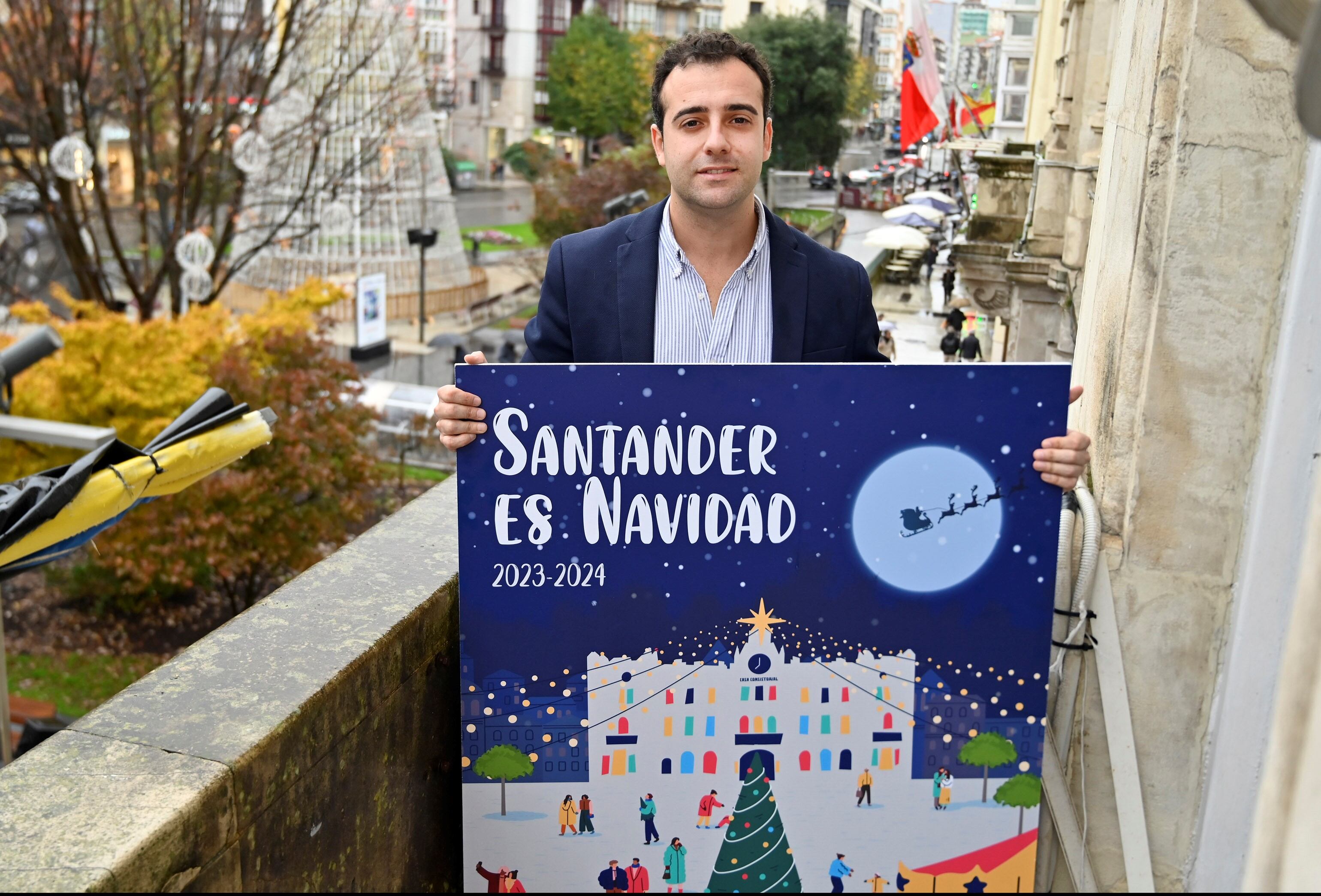 El concejal de Dinamización Social, Fran Arias en el balcón del Ayuntamiento con el cartel de la programación de la Navidad.