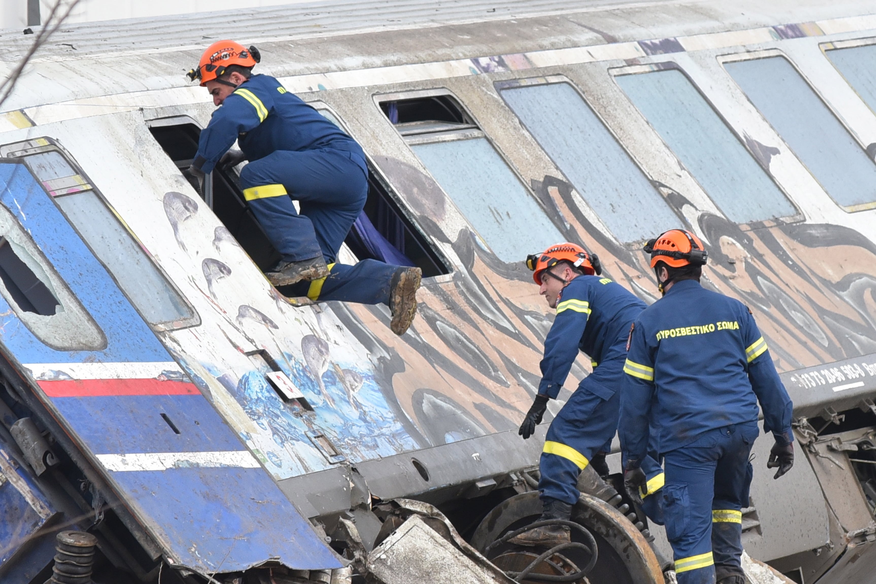 Varios bomberos realizando tareas de rescate en uno de los trenes accidentados