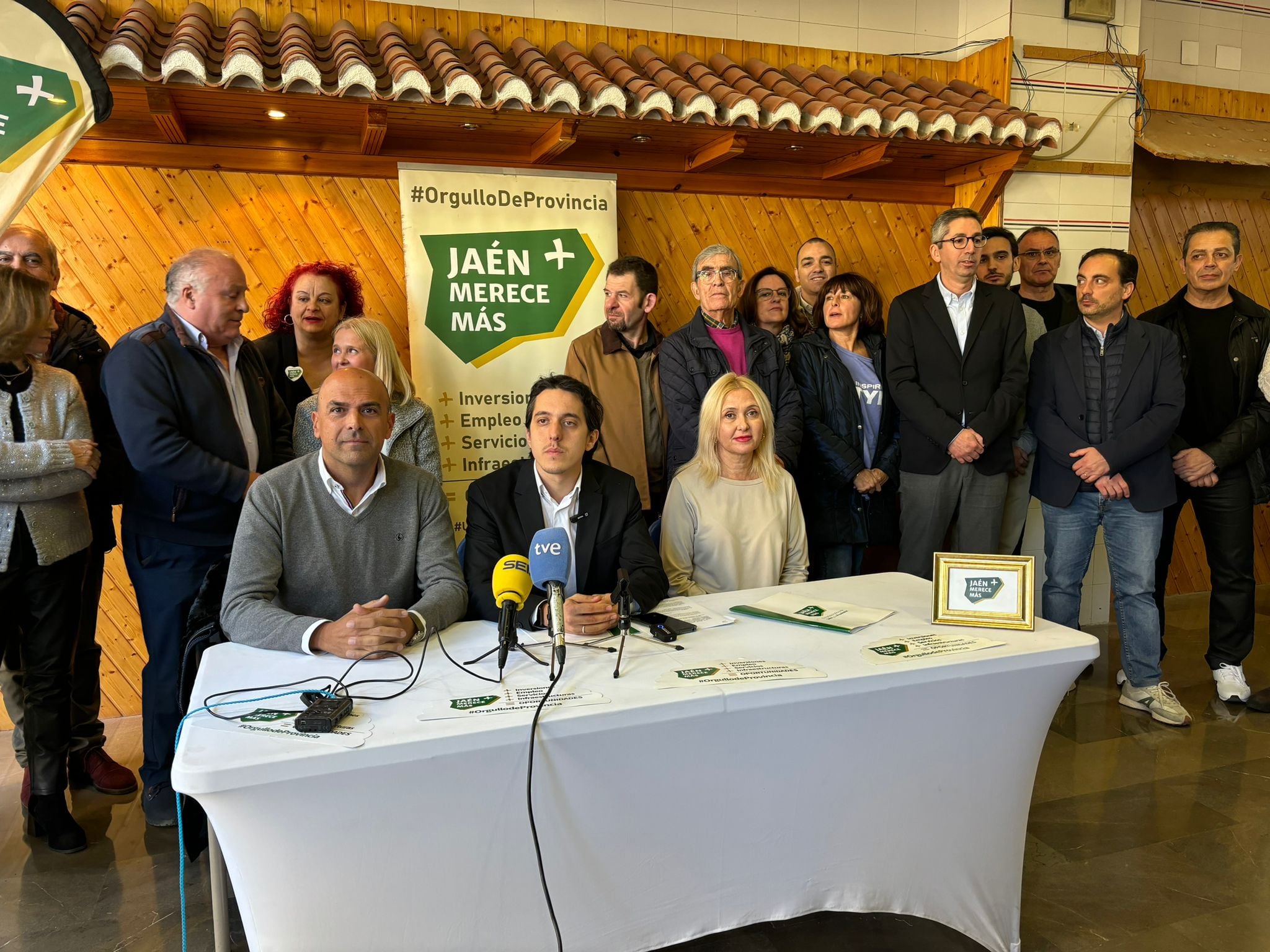 Los tres concejales de Jaén Merece Más en el Ayuntamiento de Jaén con miembros del partido detrás.