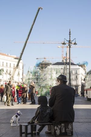 Un mimo contempla el montaje del árbol de Navidad