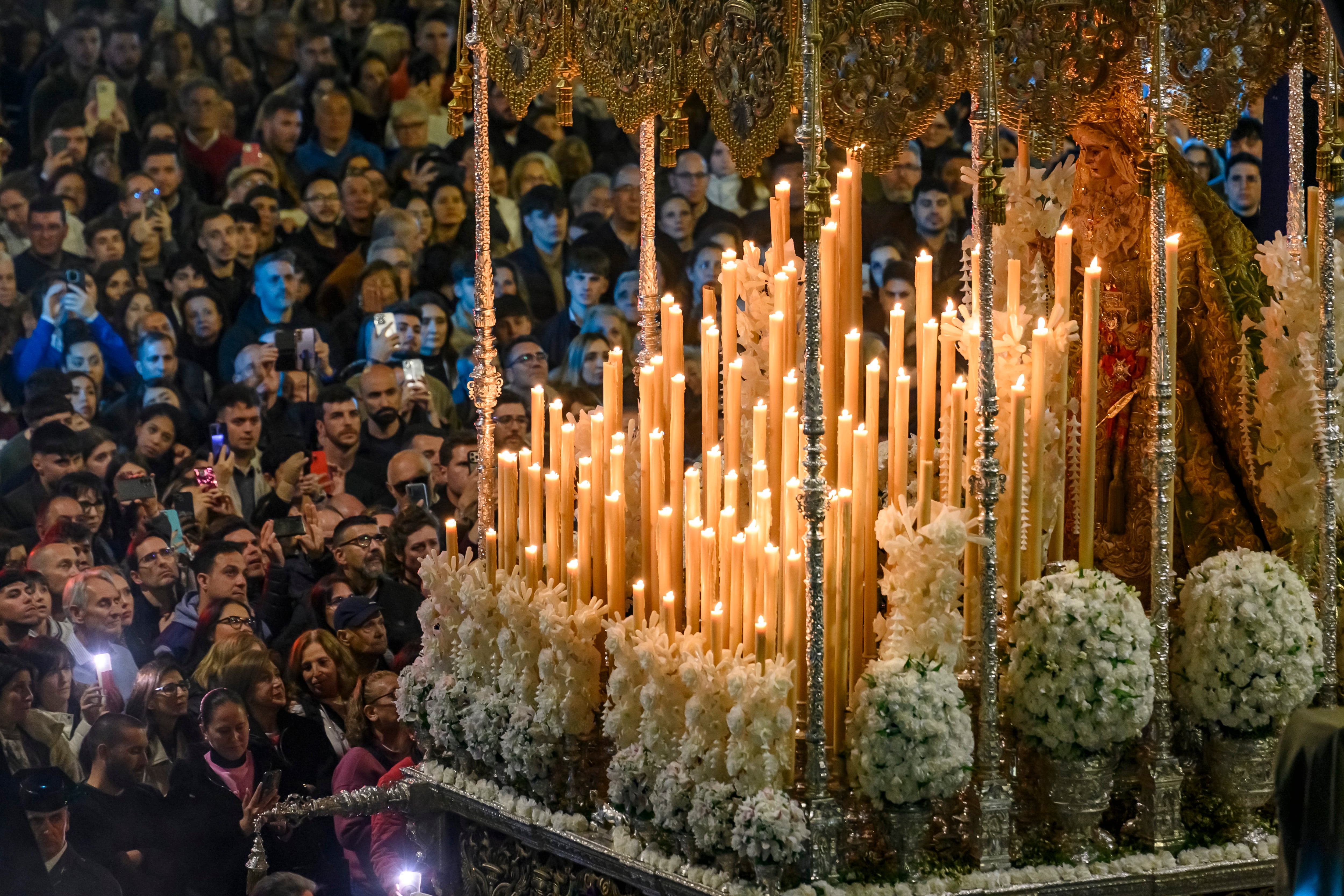 AME355. SEVILLA (ESPAÑA), 17/04/2025.- Personas participan en la salida del paso de la Virgen de la Macarena desde la Basílica, dando inicio a su estación de penitencia este jueves, en Sevilla (España). EFE/ Raúl Caro